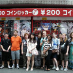 KCP students were all smiles as they posed in the middle of Akihabara. Behind them are coin lockers, fully painted with anime characters.