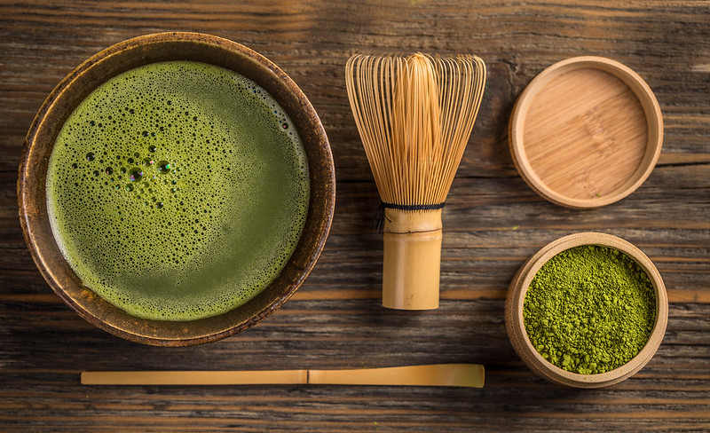 Green tea matcha in a bowl on wooden surface
