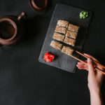 Using chosticks with sushi roll and tea