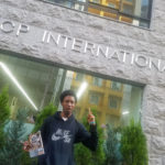 KCP student in front of KCP building