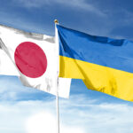 Japan and Ukraine flags against cloudy sky. waving in the sky