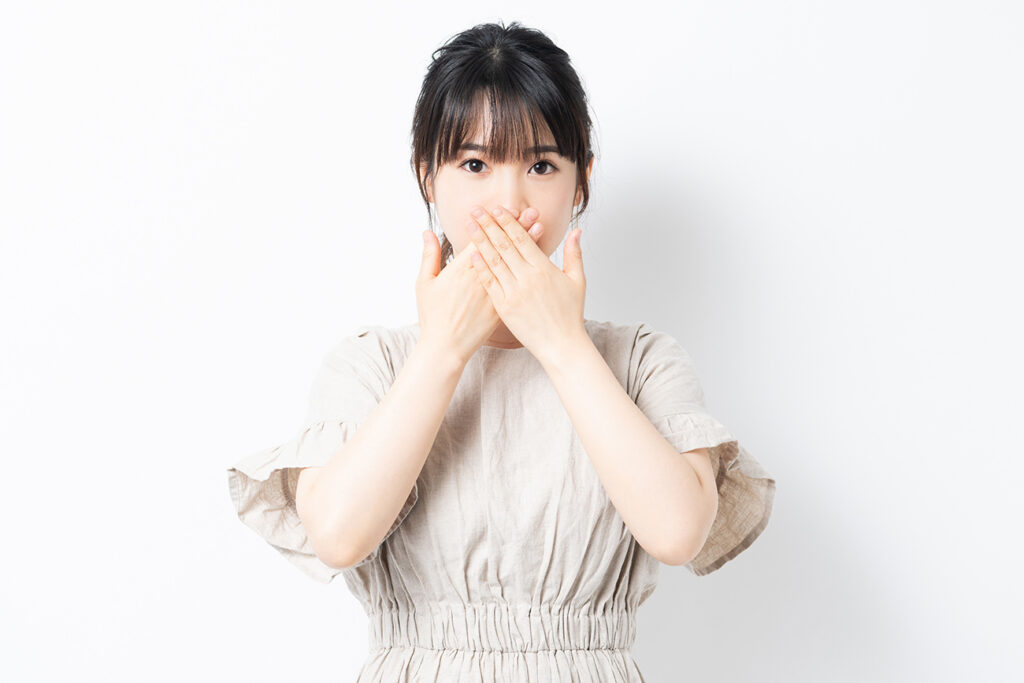 Young woman putting hands on mouth
