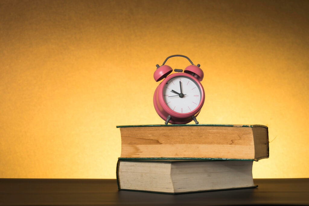 Symbolic hard study is powerful to succeed, concept with book and alarm clock. Time in business and quality