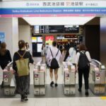 people passing through transit gates in Japan