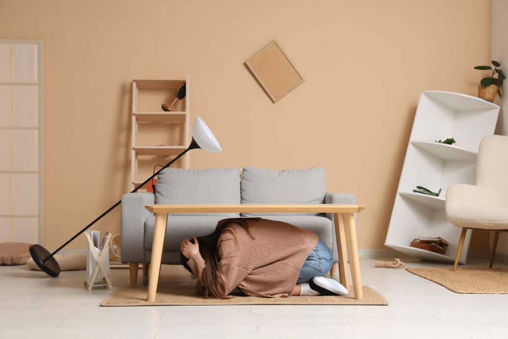 image of scared woman hiding under table